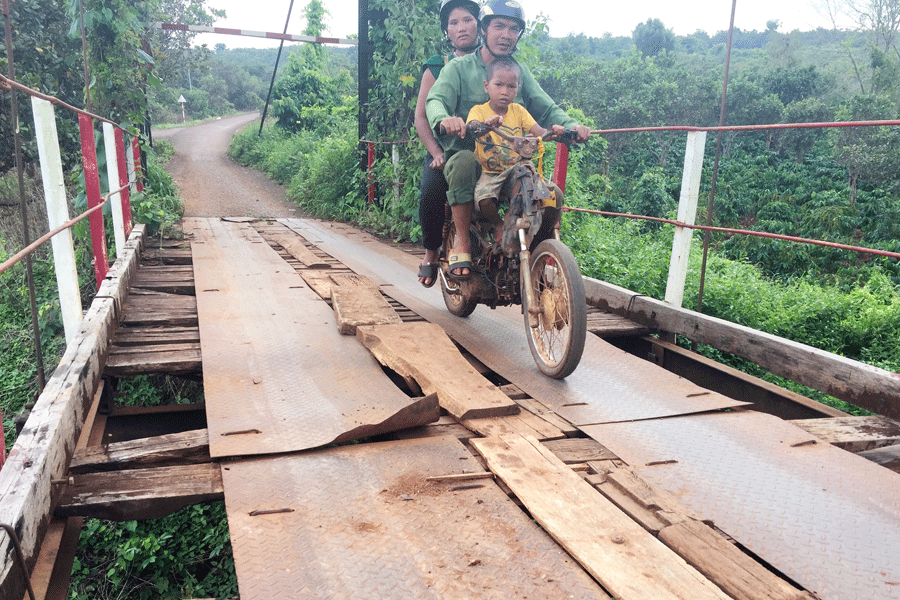 Dù nguy hiểm nhưng người dân vẫn phải qua lại trên cây cầu xuống cấp này. Ảnh: V.N