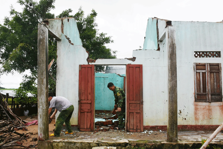 Lực lượng vũ trang giúp gia đình ông Đinh Rôih (xã Tú An, thị xã An Khê) thu dọn đống đổ nát sau mưa bão.        Ảnh: N.T