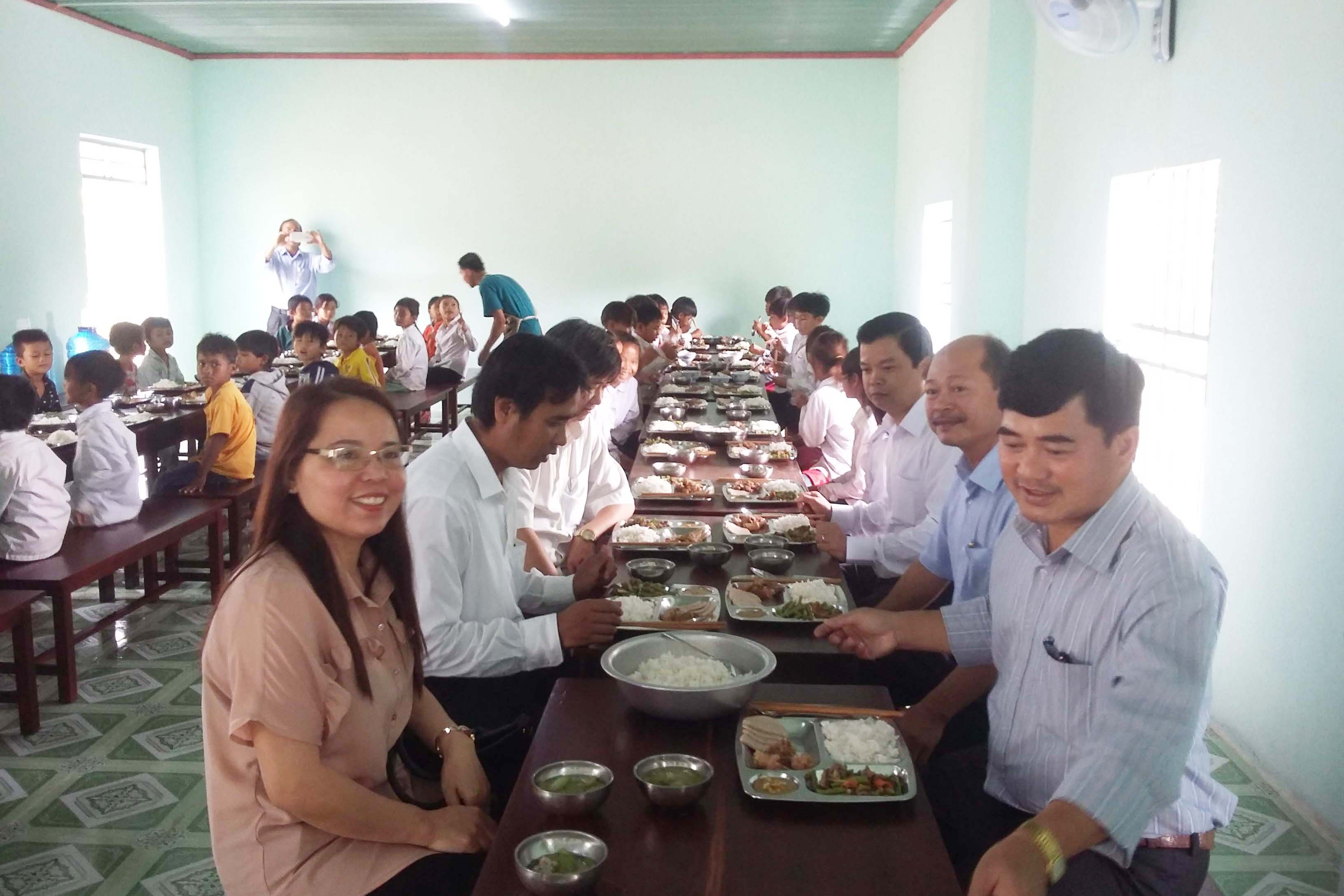 Đại diện các nhà tài trợ và lãnh đạo huyện Phú Thiện dùng cơm cùng các em học sinh. Ảnh: L.A