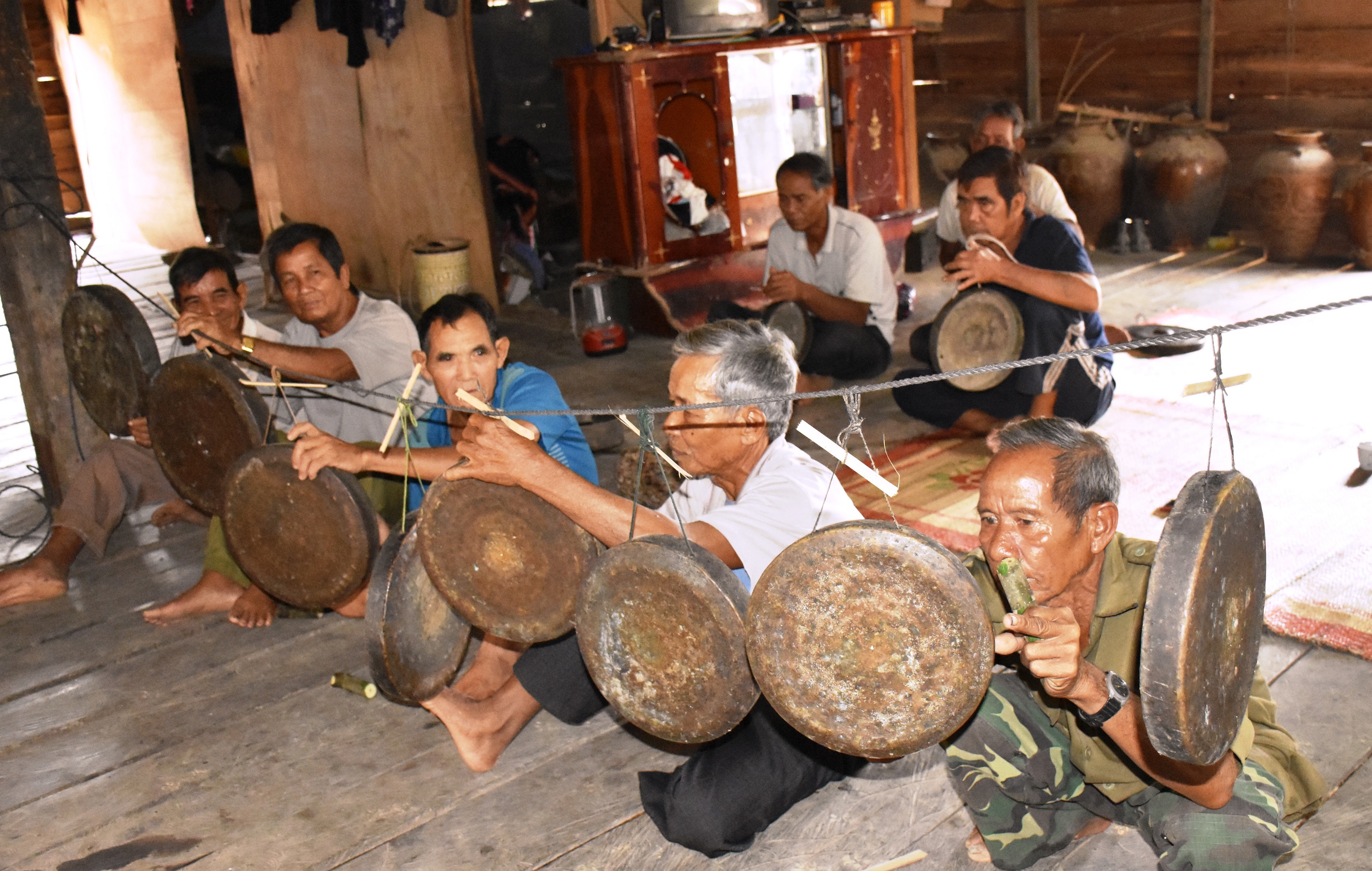 Một vài người già trong làng đưa bộ cồng chiêng ra ngắm và đánh vài nhịp quen thuộc. Ảnh: Trần Dung