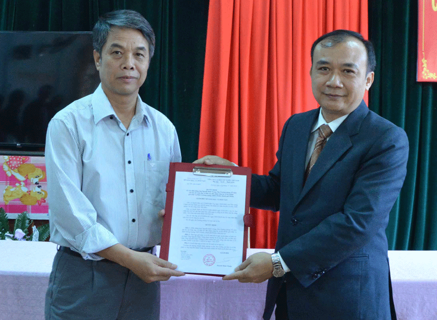 Ông Huỳnh Minh Thuận (phải) trao quyết định cho Hiệu trưởng Nguyễn Đình Trung (trái). Ảnh: M.V