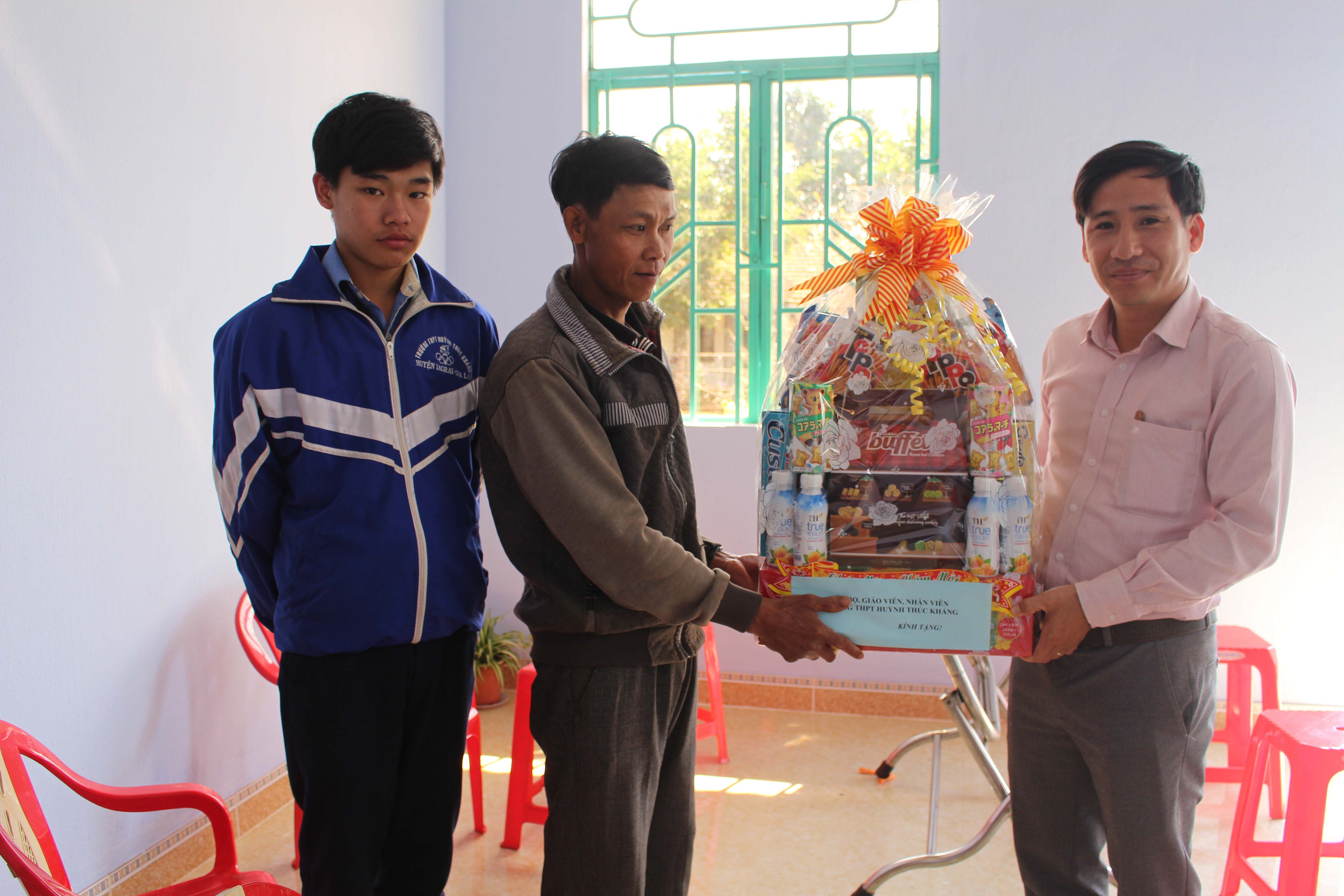 Thầy cô Trường THPT Huỳnh Thúc Kháng chúc Tết gia đình em Trung.   Ảnh: N.G