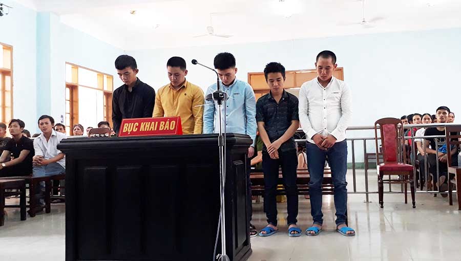   Các bị cáo đứng trước vành móng ngựa trong phiên tòa xét xử sơ thẩm. Ảnh: Văn Ngọc 