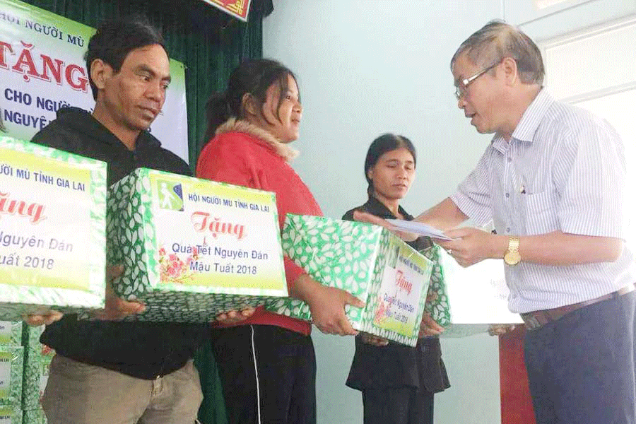 Ông Nguyễn Văn Hùng-Chủ tịch Hội Người mù tỉnh tặng quà cho người khiếm thị.                                Ảnh: Đ.Y