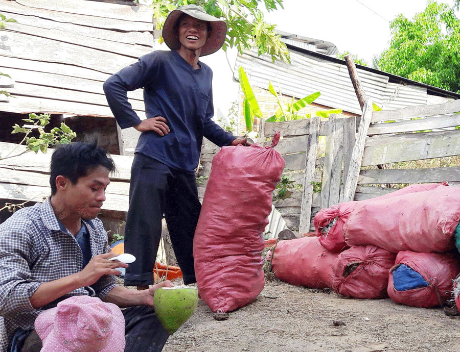 Anh Lò Văn Chinh (đứng) cùng bạn nghỉ giải lao sau mấy tiếng bốc vác phân bò. Ảnh: Đ.Y