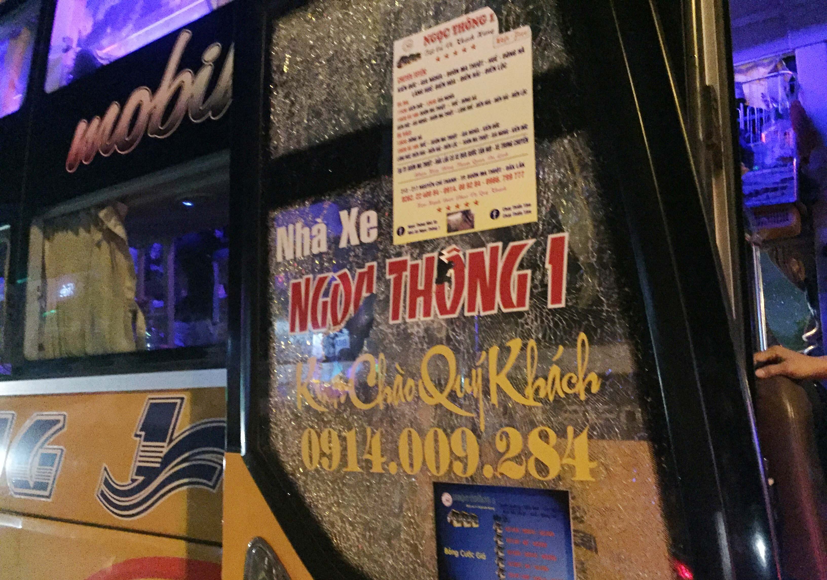 Tấm cửa kính của xe khách bị nhóm côn đồ dùng hung khí và dùng đá ném vỡ.  Ảnh: Văn Ngọc 