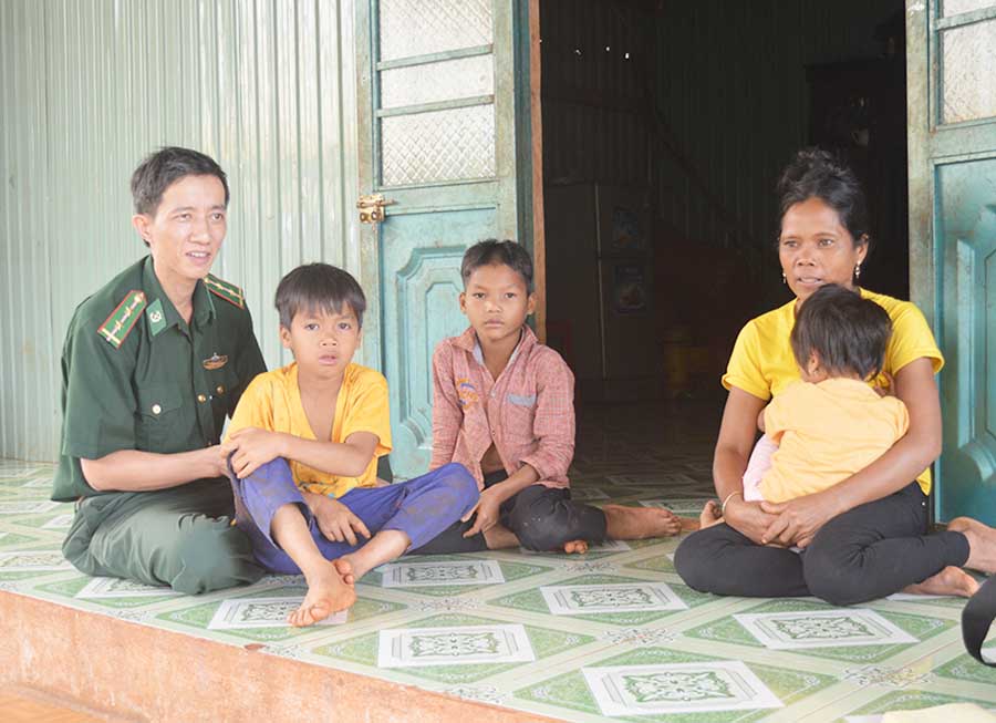   Thượng úy Ngô Văn Hữu vận động chị Siu Bia quan tâm hơn đến việc học của 2 đứa con.    Ảnh: P.D