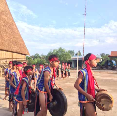 Đội chiêng nhí làng Kon So Lawl, huyện Chư Pah đang biểu diễn trước nhà rông của làng. Ảnh: Võ thanh Thảo