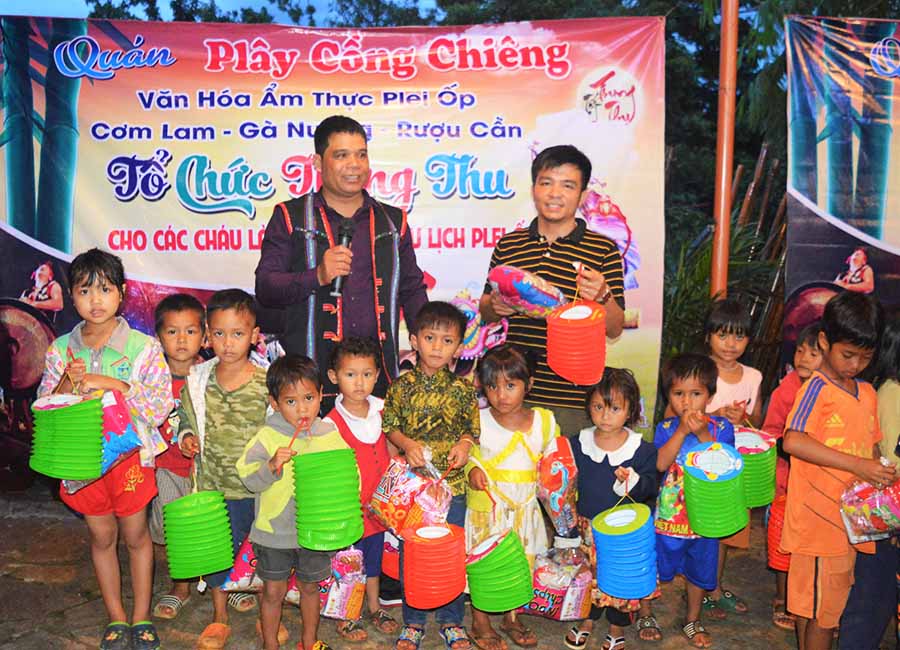 Quán Plây Cồng chiêng tặng quà cho trẻ em làng văn hóa du lịch Plei Ốp. Ảnh: Đ.Y
