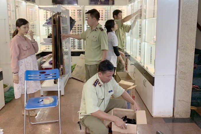 Lực lượng chức năng đang kiểm tra tại cửa hàng kính mắt vbtt