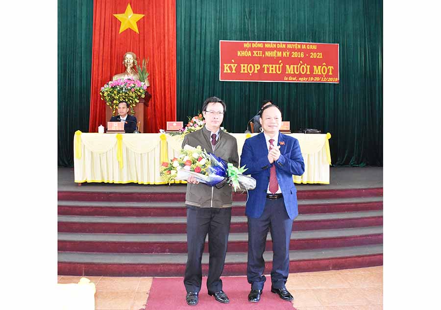 Chủ tịch HĐND huyện Dương Mah Tiệp (bìa phải)  tặng hoa chúc mừng  Chủ tịch UBND huyện Lê Ngọc Quý. Ảnh: Phan Thương
