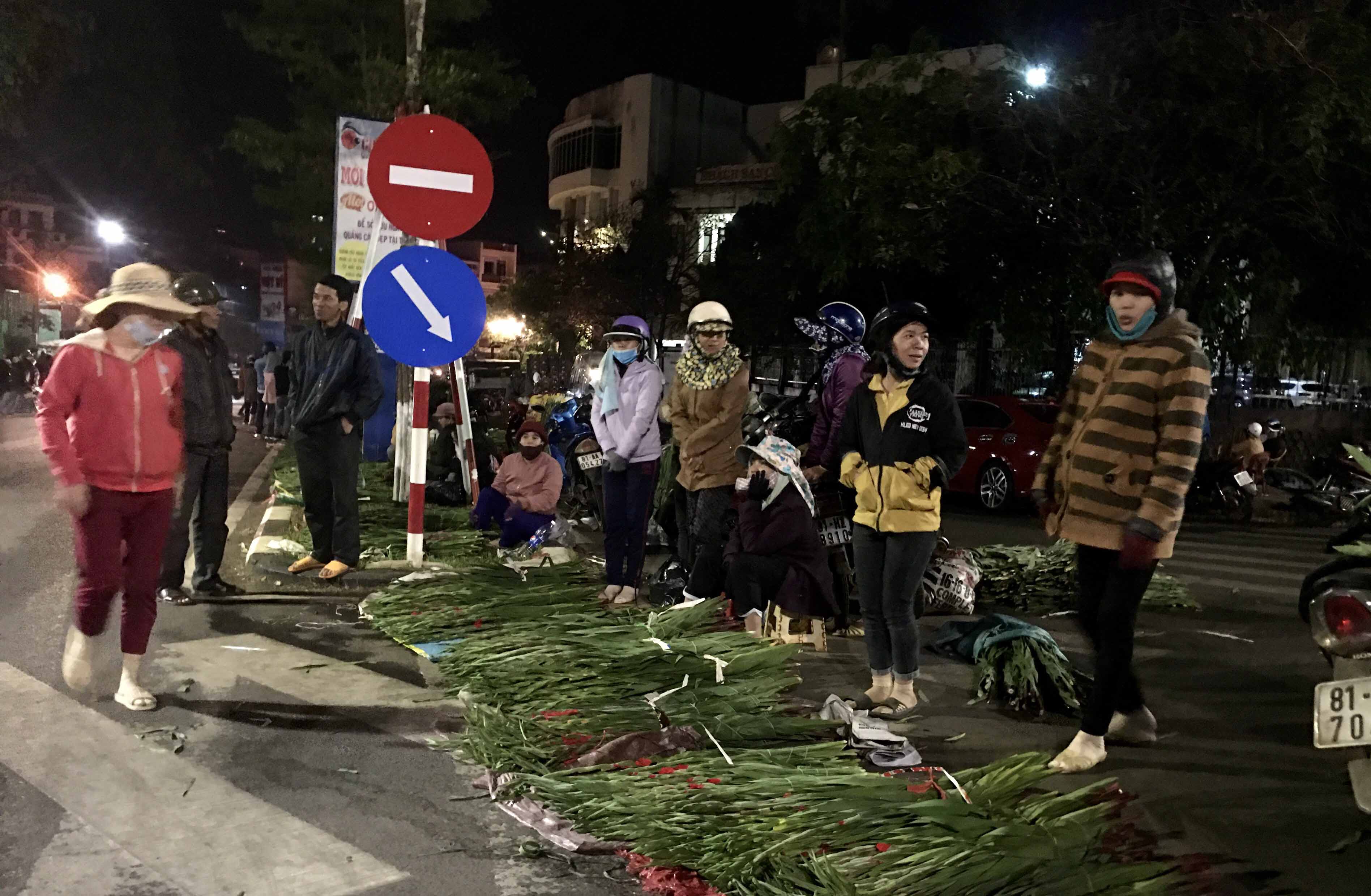 Những người phụ nữ bán hoa lay ơn co ro trong cái lạnh đêm Pleiku. Ảnh: Lê Hòa