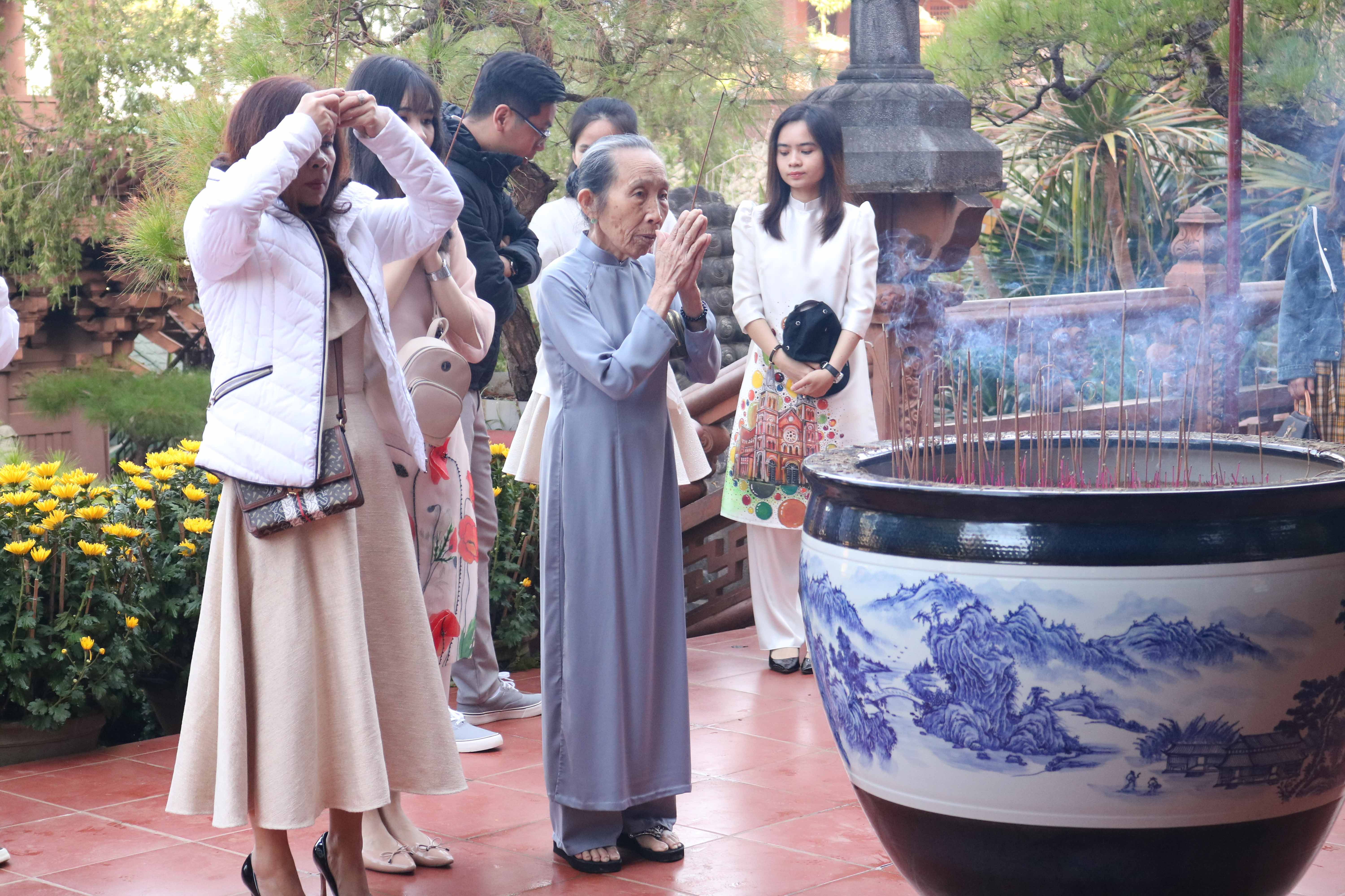  Bà Nguyễn Thị Nữ cùng các con, cháu đi lễ đầu năm cầu mong năm mới mọi sự tốt lành đến với gia đình. Ảnh: Ngọc Sang