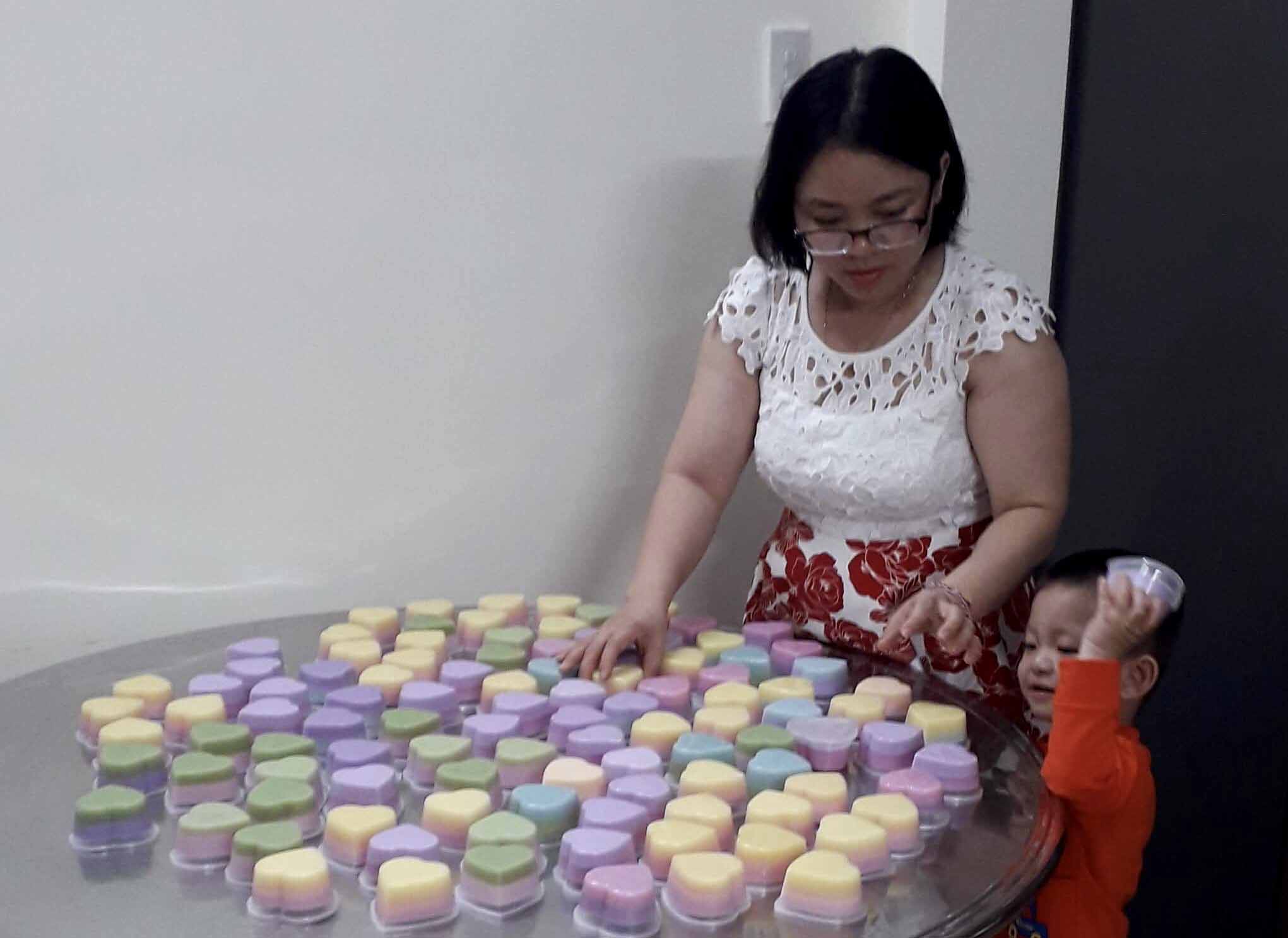 Chị Ngân bên một mẻ bánh rau câu nấu từ màu tự nhiên vừa hoàn thành cho khách đặt ăn trong dịp Tết. Ảnh: Hải Lê