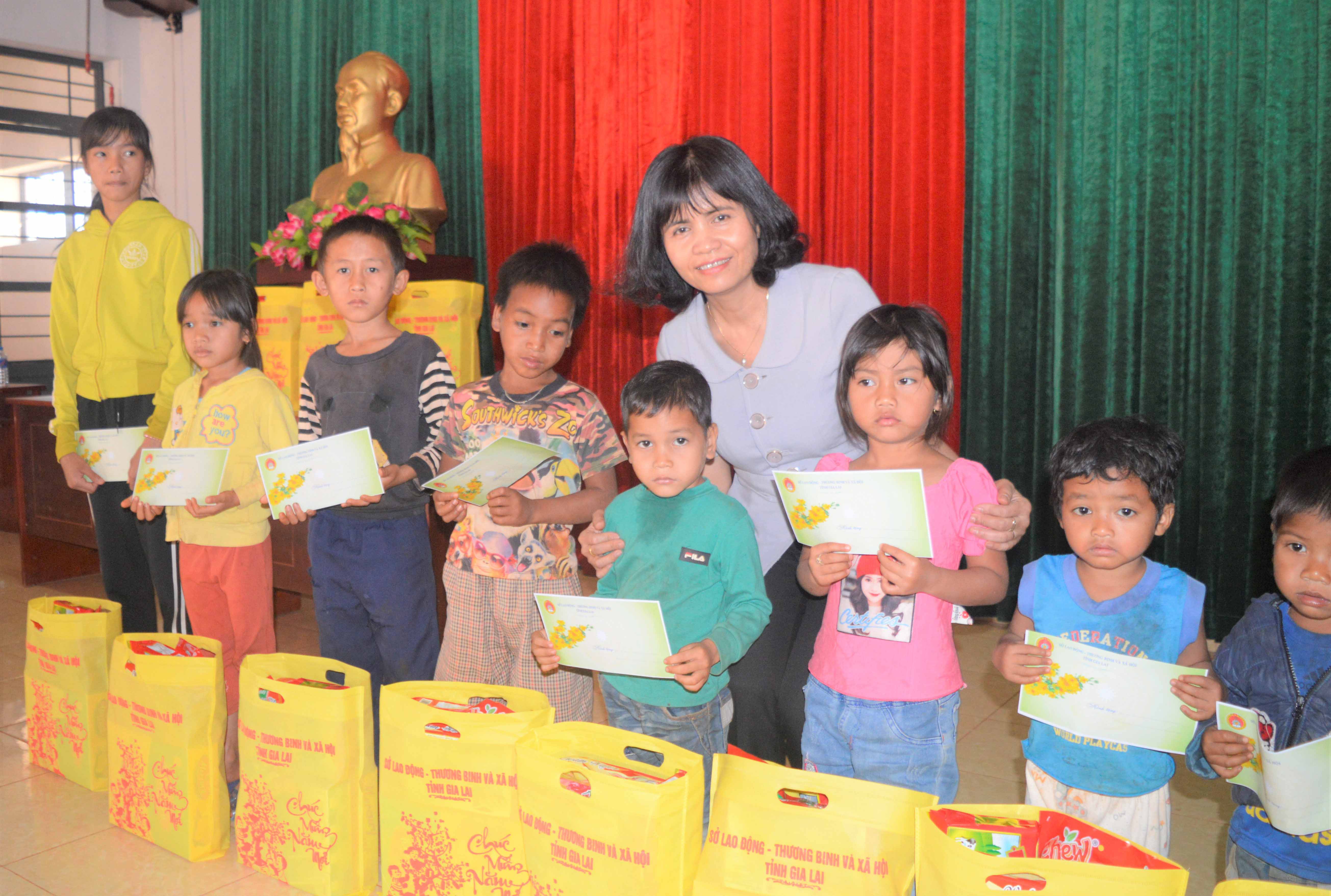 Bà Rcom Sa Duyên tặng quà cho trẻ em nghèo xã Ia Pnôn. Ảnh: Đinh Yến