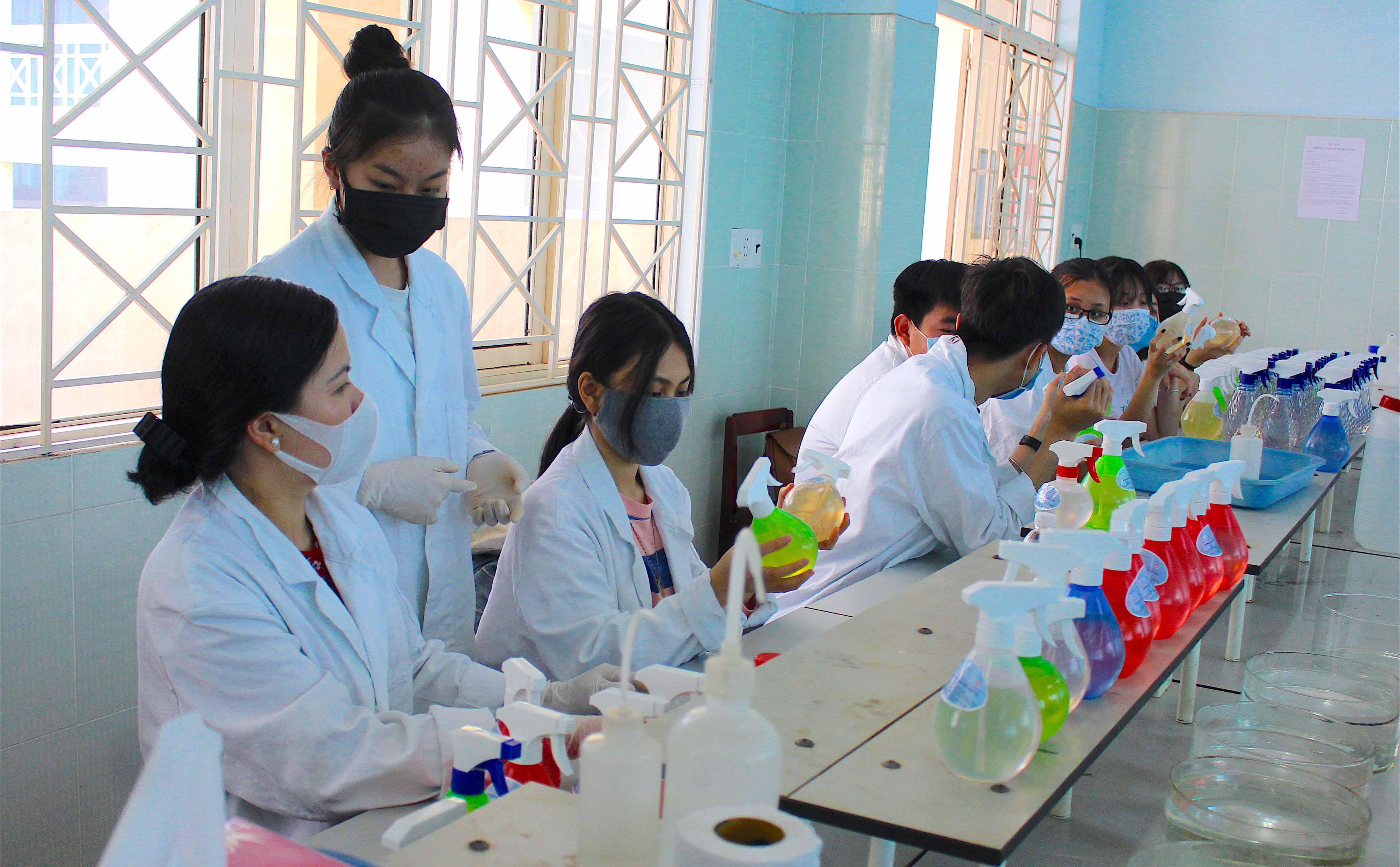 Cô và trò Trường THPT chuyên Hùng Vương cùng nhau pha chế dung dịch rửa tay khô tại phòng thí nghiệm của trường. Ảnh: Mộc Trà