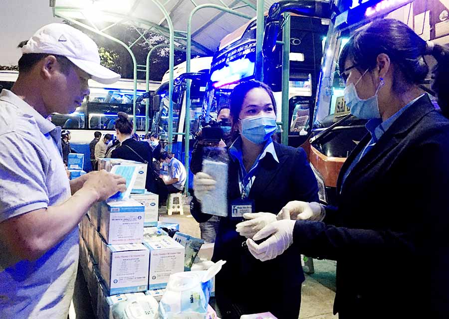   Nhân viên của nhà xe Thuận Tiến Gia Lai phát khẩu trang, khăn ướt tẩm cồn  70 độ cho hành khách tại Bến xe Đức long Gia Lai. Ảnh: L.H