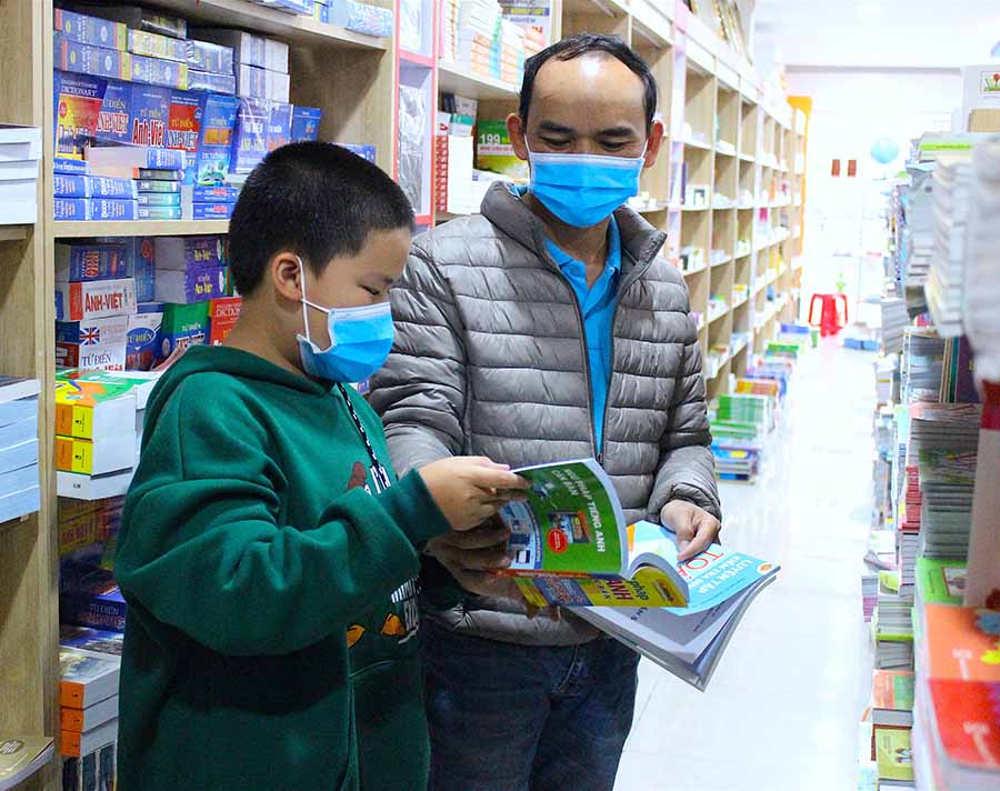 Anh Lê Văn Thuận (phường Hoa Lư, TP. Pleiku) dẫn con trai đi mua sách. Ảnh: M.T