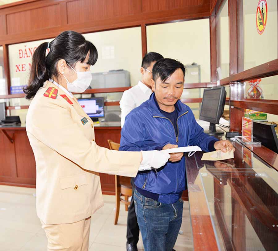 Cán bộ Phòng Cảnh sát giao thông, Công an tỉnh cấp phát khẩu trang miễn phí cho người dân đến giải quyết công việc. Đồng thời yêu cầu người dân đeo khẩu trang khi làm việc. Ảnh: H.T