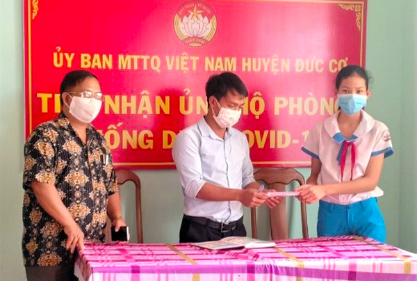 Ông Siu Thi (bìa trái)-Chủ tịch Ủy ban MTTQ Việt Nam huyện Đức Cơ cùng cán bộ nhận số tiền em Nguyễn Phúc Bảo Trâm tặng. Ảnh: H.T
