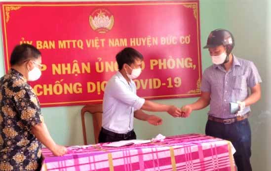 Cán bộ Ủy ban MTTQ Việt Nam huyện Đức Cơ tiếp nhận tiền ủng hộ của người dân. Ảnh: Đinh Yến