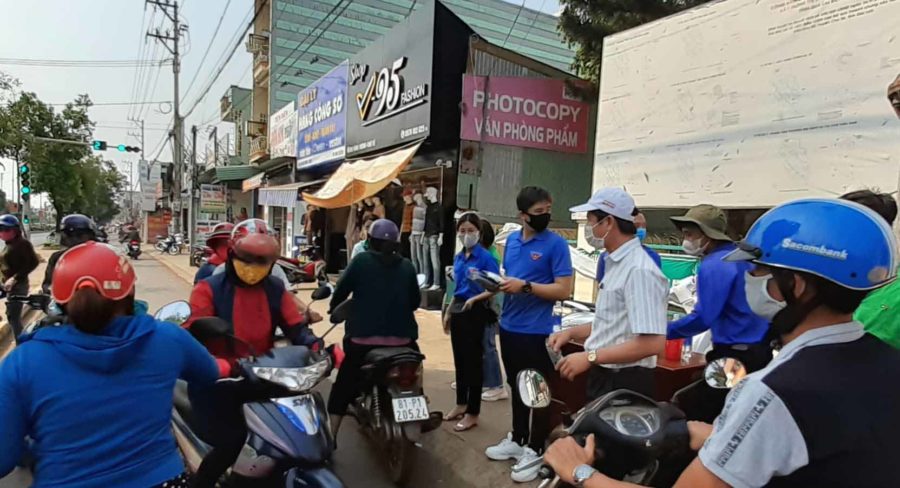 Các tình nguyện viên và lãnh đạo thị trấn Chư Sê tham gia phát khẩu trang tại cổng UBND thị trấn. Ảnh: Hoàng Viên 