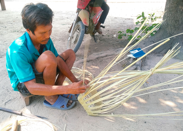 Ông Ksor Thăm (trú thôn Bah Leng, xã Ia Ma rơn, huyện Ia Pa) tỉ mỉ từng thao tác để  đan chiếc gùi tre. Ảnh-R'Ô Hok (3). Ảnh: R.H