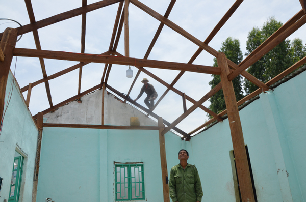 Thôn trưởng Vòng Bong-Rơ Com Tuen nhìn căn nhà bị gió cuốn bay hoàn toàn mái tôn của gia đình mình. Ảnh: Đ.P