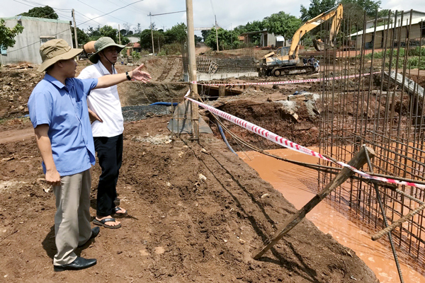 Cán bộ Ban Quản lý dự án Đầu tư Xây dựng huyện Chư Pưh kiểm tra tiến độ thi công công trình cầu bắc qua suối Ia Hlốp. Ảnh: N.S