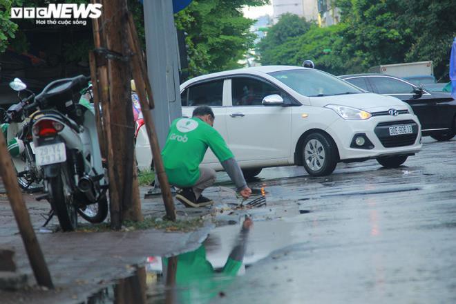 Tài xế xe ôm khơi thông cống thoát nước trên phố Hà Nội sau trận mưa lớn Ảnh 4