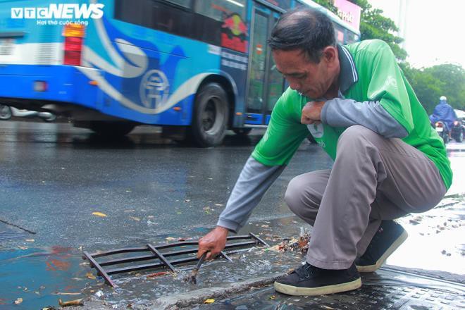 Tài xế xe ôm khơi thông cống thoát nước trên phố Hà Nội sau trận mưa lớn Ảnh 6