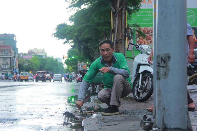 Tài xế xe ôm khơi thông cống thoát nước trên phố Hà Nội sau trận mưa lớn Ảnh 5