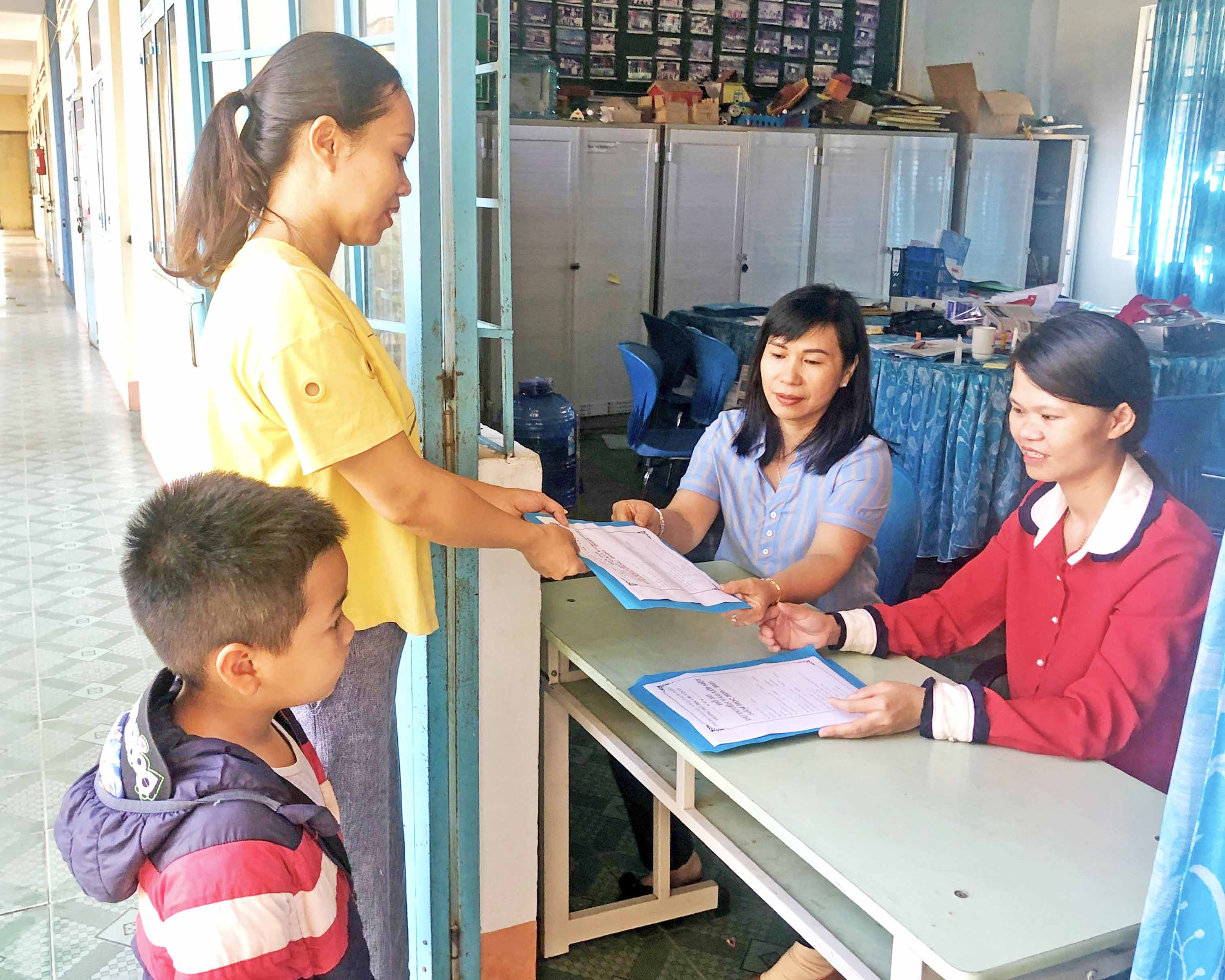  Phụ huynh nộp hồ sơ nhập học cho con tại Trường Tiểu học Chu Văn An (phường Tây Sơn, TP. Pleiku). Ảnh: NGỌC THU