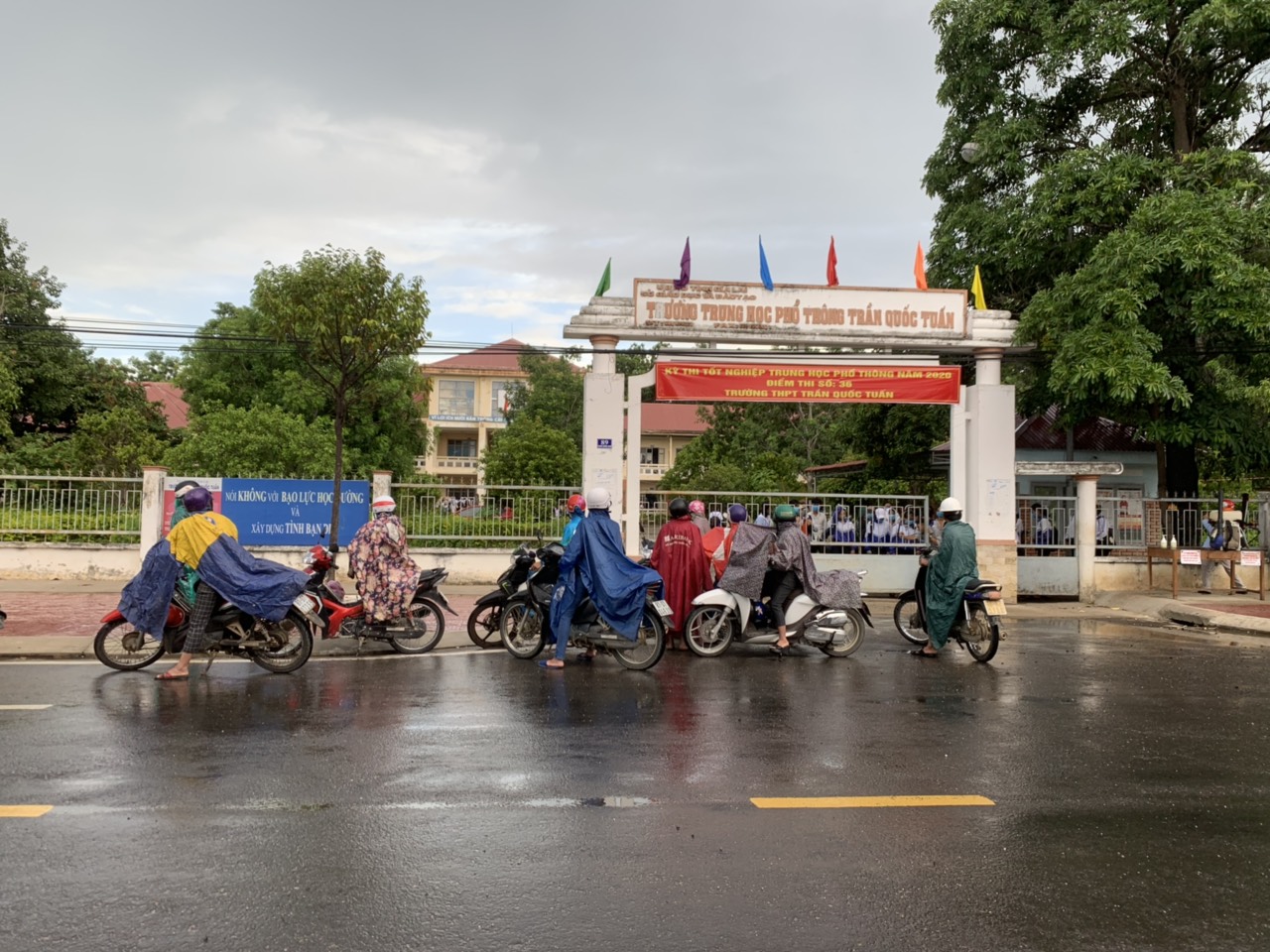 Trời mưa to, nhiều phụ huynh ở huyện Phú Thiện đến các điểm thi sớm để đón con. Ảnh: Vũ Chi