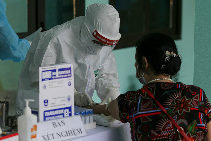 Nhân viên y tế phường Yên Hòa, quận Cầu Giấy, Hà Nội lấy mẫu máu xét nghiệm cho người về từ Đà Nẵng, ngày 30/7. Ảnh: Tất Định.