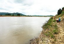 Người dân buôn H'Lang (xã Chư Rcăm) bên bờ một đoạn sông bị dòng nước lớn cuốn tạo thành bờ vách cao cả chục mét. Ảnh: Quang Ngọc