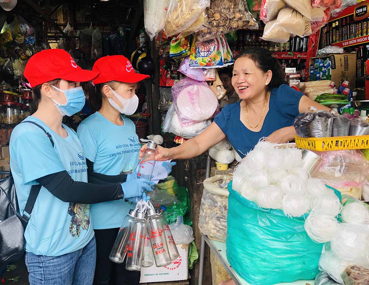  Nhân viên Văn phòng Tổng đại lý Prudential Gia Lai tặng chai đựng nước thủy tinh cho các tiểu thương Trung tâm Thương mại Pleiku. Ảnh: Phan Lài