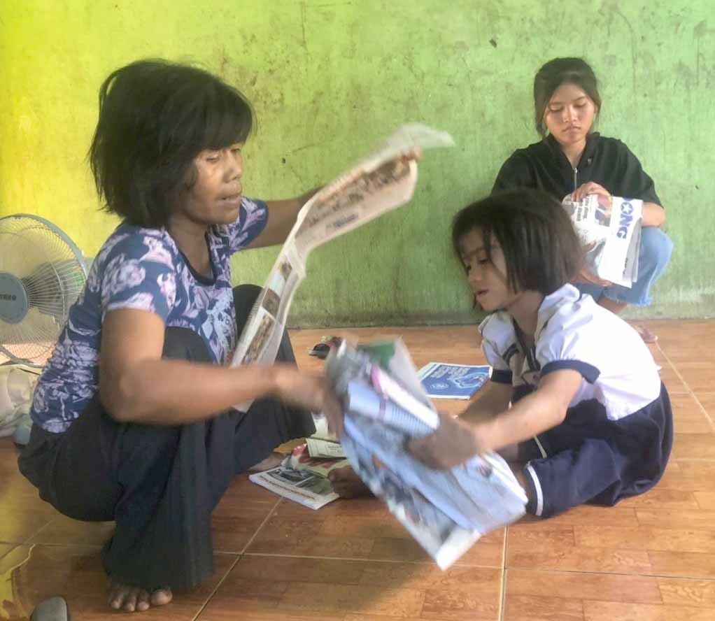 Bà Đinh Nay Huỳnh (làng Tung Ke, xã Ayun, huyện Chư Sê) và con gái nuôi chuẩn bị sách vở cho năm học mới. Ảnh: Anh Huy 