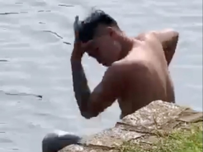 Trước khi bơi ra giữa lòng hồ Bảo Lộc, nam thanh niên la hét và có nhiều hành động nghi ngáo đá /// Ảnh: Trùng Dương