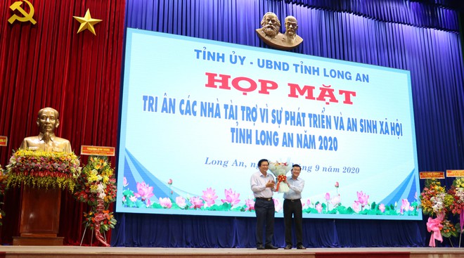 Ông Phạm Văn Rạnh, Bí thư Tỉnh ủy Long An (trái) tặng hoa tri ân cho Nguyên Chủ tịch nước Trương Tấn Sang /// ẢNH: B.B