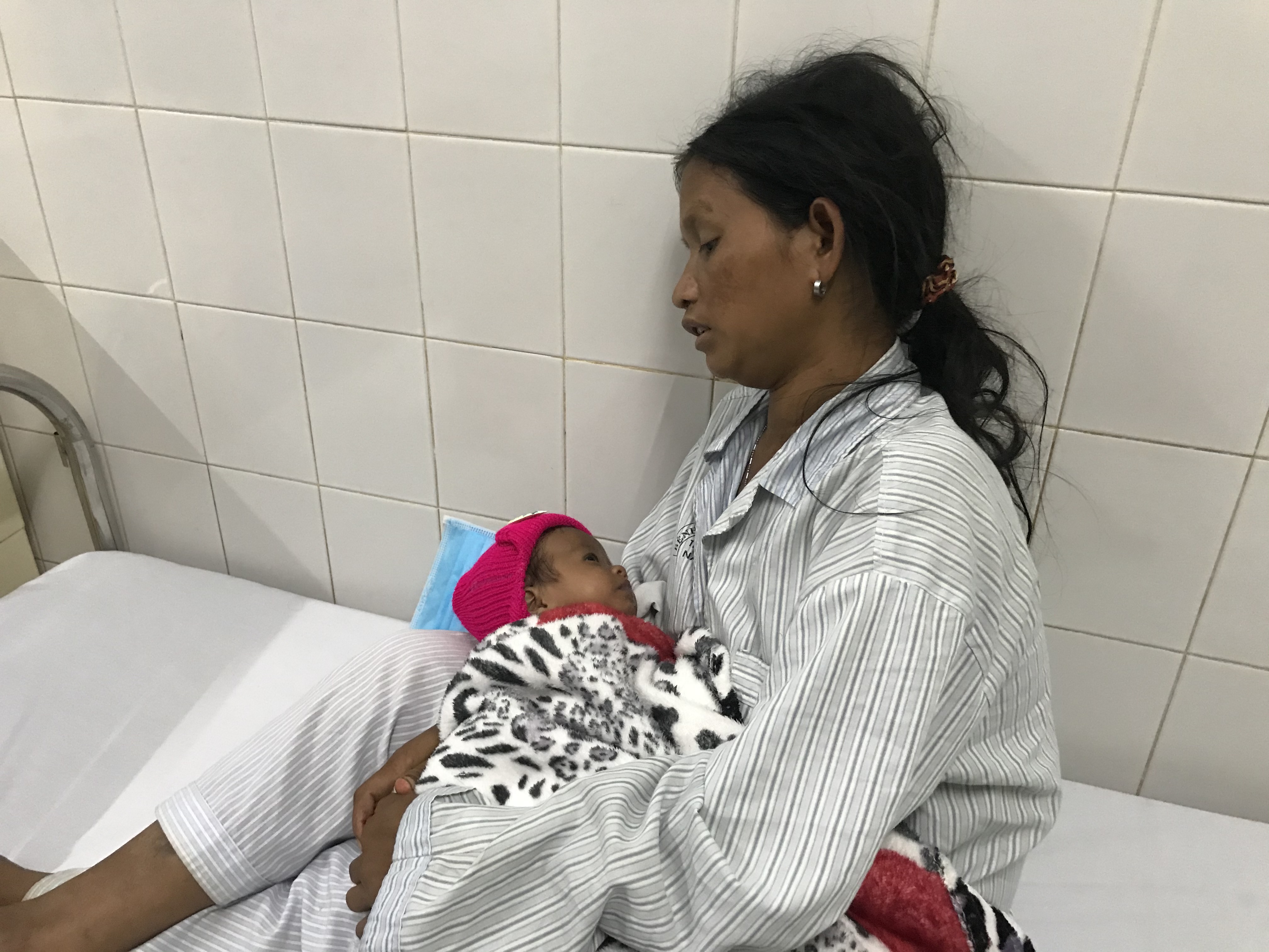 Chị Đinh Thị Bel ôm con trai 1 tháng tuổi vào lòng trong sự đau đớn. Ảnh: Lê Văn Ngọc
