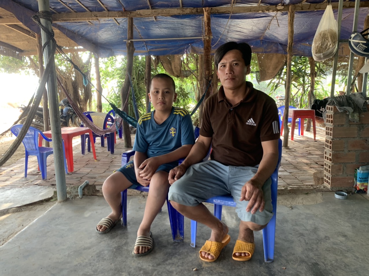 Anh Nguyễn Văn Khánh cùng con trai Nguyễn Văn Nhẫn bên quán nước của gia đình. Ảnh: Vũ Chi