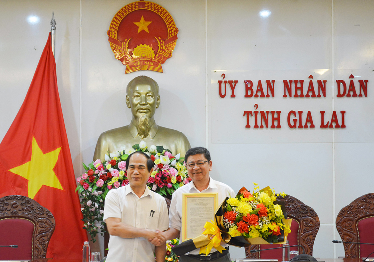 Chủ tịch UBND tỉnh Võ Ngọc Thành (bìa trái) trao Quyết định và tặng hoa chúc mừng cho đồng chí Nguyễn Văn Lộc. Ảnh: Hồng Thi
