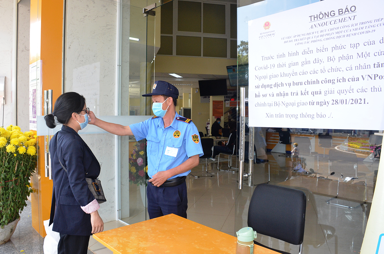 Người dân đến liên hệ công việc tại Trung tâm Phục vụ hành chính công đều phải đo thận nhiệt, rửa tay sát  khuẩn. Ảnh: Vĩnh Hoàng