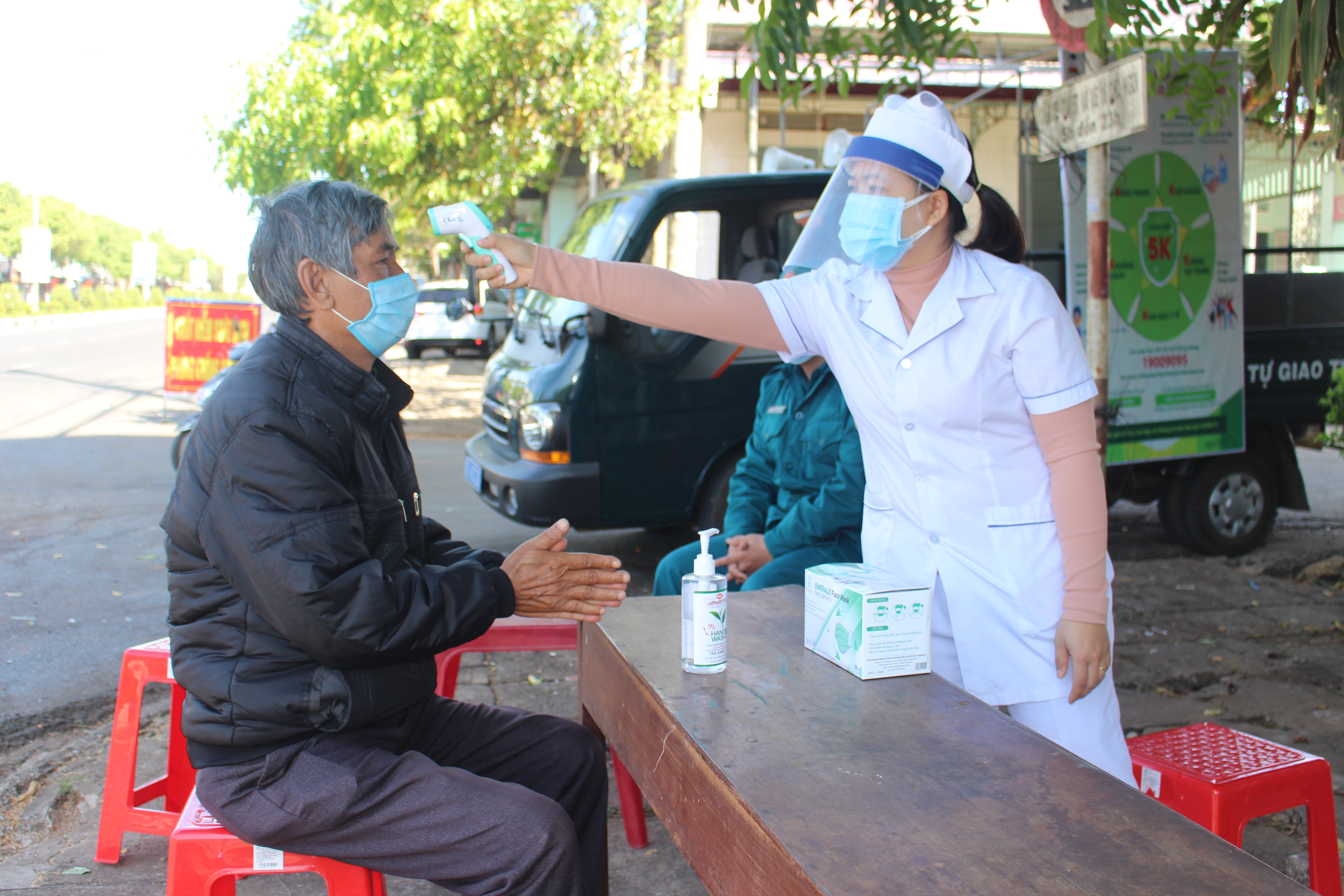 Nhân viên y tế phường Đống Đa đo thân nhiệt cho người dân. Ảnh: Phan Lài