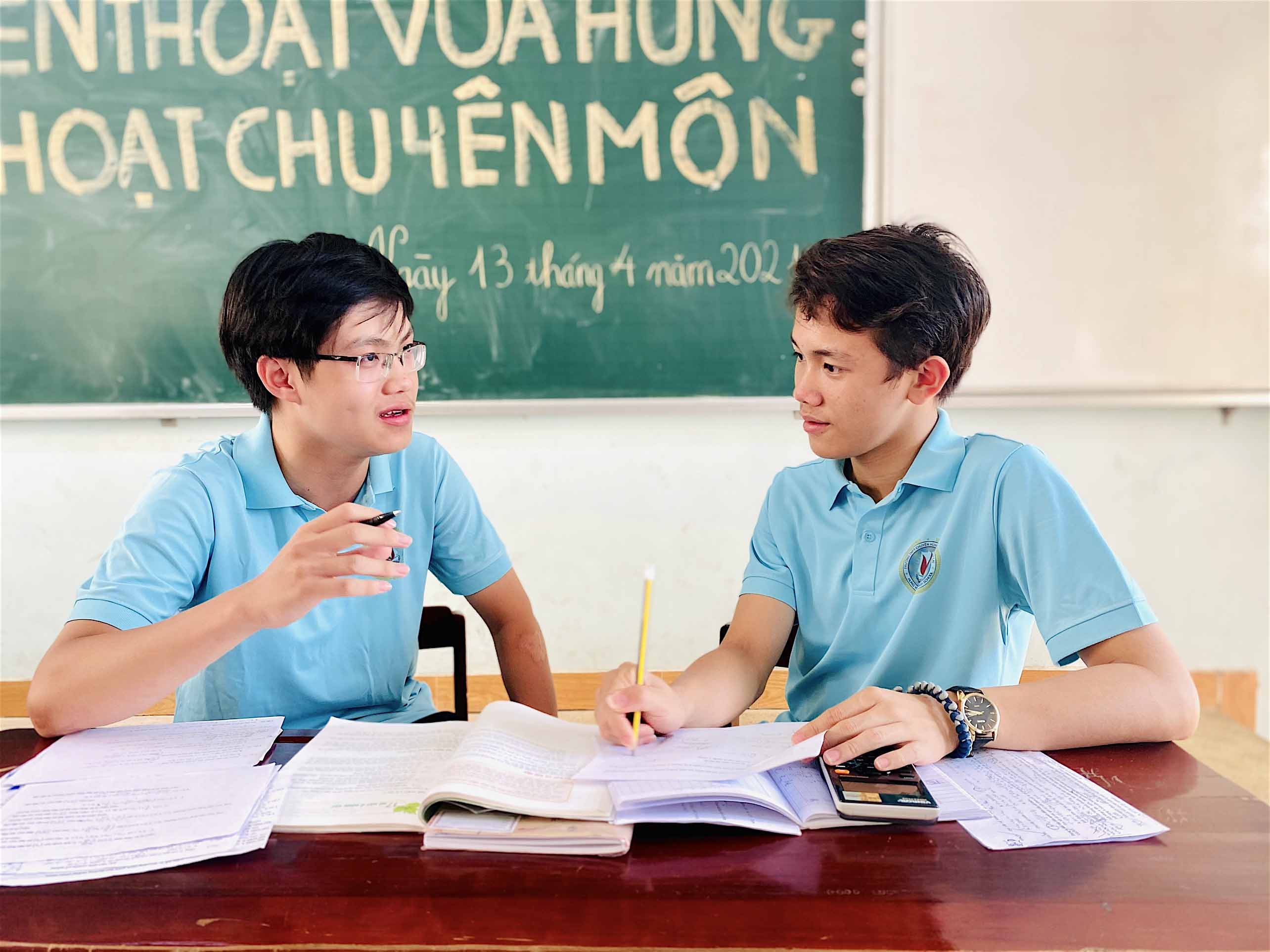 Chủ nhiệm CLB Trần Nhật Quang (bìa trái) chia sẻ kinh nghiệm “leo núi” cho em Nguyễn Vũ Nhật Huy để gặt hái được thành tích cao tại cuộc thi Đường lên đỉnh Olympia tại VTV. Ảnh: Mộc Trà