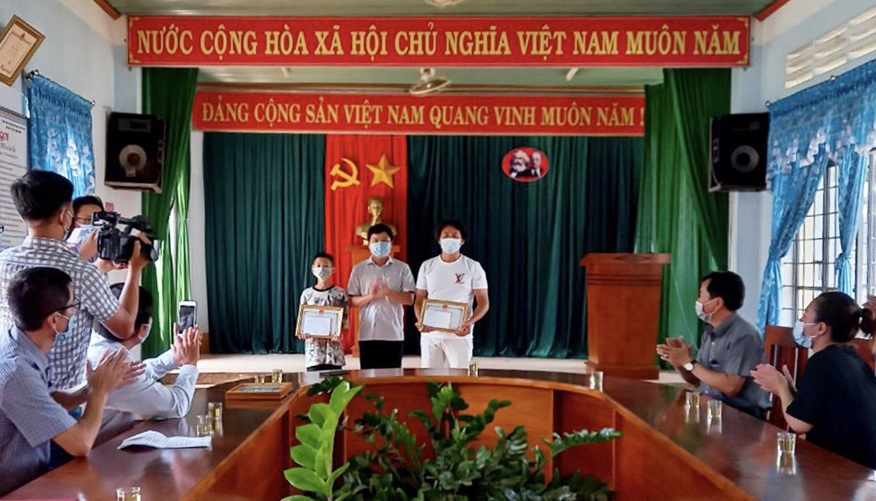 Chủ tịch UBND TP. Pleiku Nguyễn Hữu Quế tặng giấy khen cho cháu Duy và ông Quốc.  Ảnh: Văn Ngọc