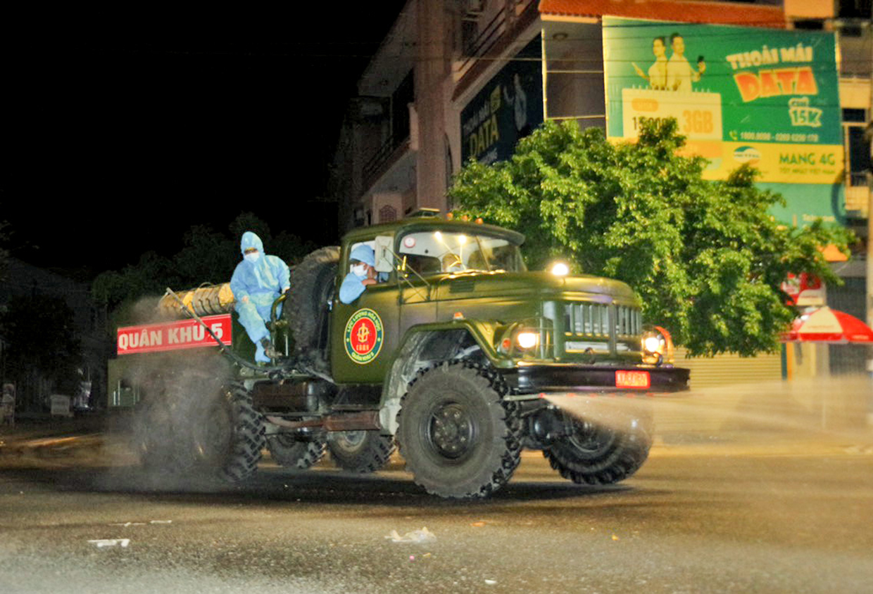 Phun khử khuẩn mặt đường tại thị trấn Phú Túc trong tối ngày 16-7.