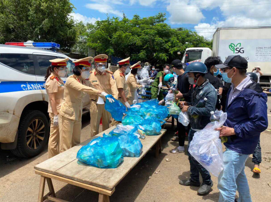 Lực lượng Cảnh sát Giao thông tỉnh hỗ trợ lương thực cho người dân về từ các tỉnh phía Nam tại chốt kiểm soát phòng-chống dịch Covid-19 khu vực cầu 110 (huyện Chư Pưh). Ảnh: Lê Anh