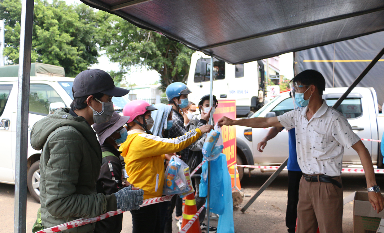 Lực lượng chức năng huyện Chư Pưh phối hợp với Ủy ban MTTQ Việt Nam tỉnh phát thức ăn cho công dân trở về từ các tỉnh, thành phía Nam. Ảnh: Quang Tấn